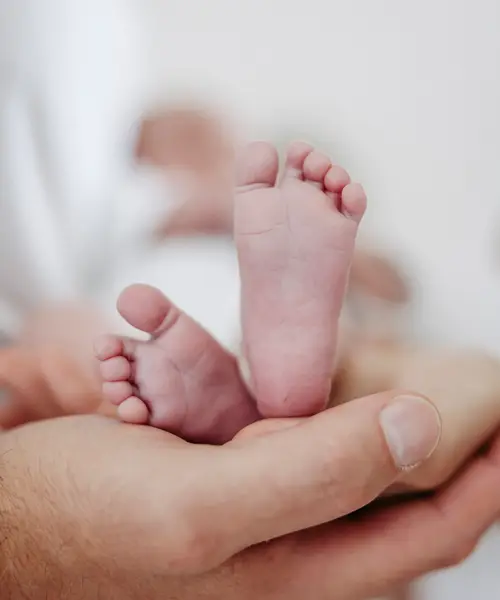 Füßchen eines Neugeborenen in der Hand der Mutter